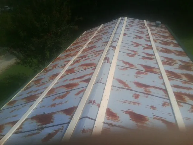Rusted metal roof panels with new wood purlins before replacement — Storm Damage Roof Repair in Kenly by Roofing Brothers