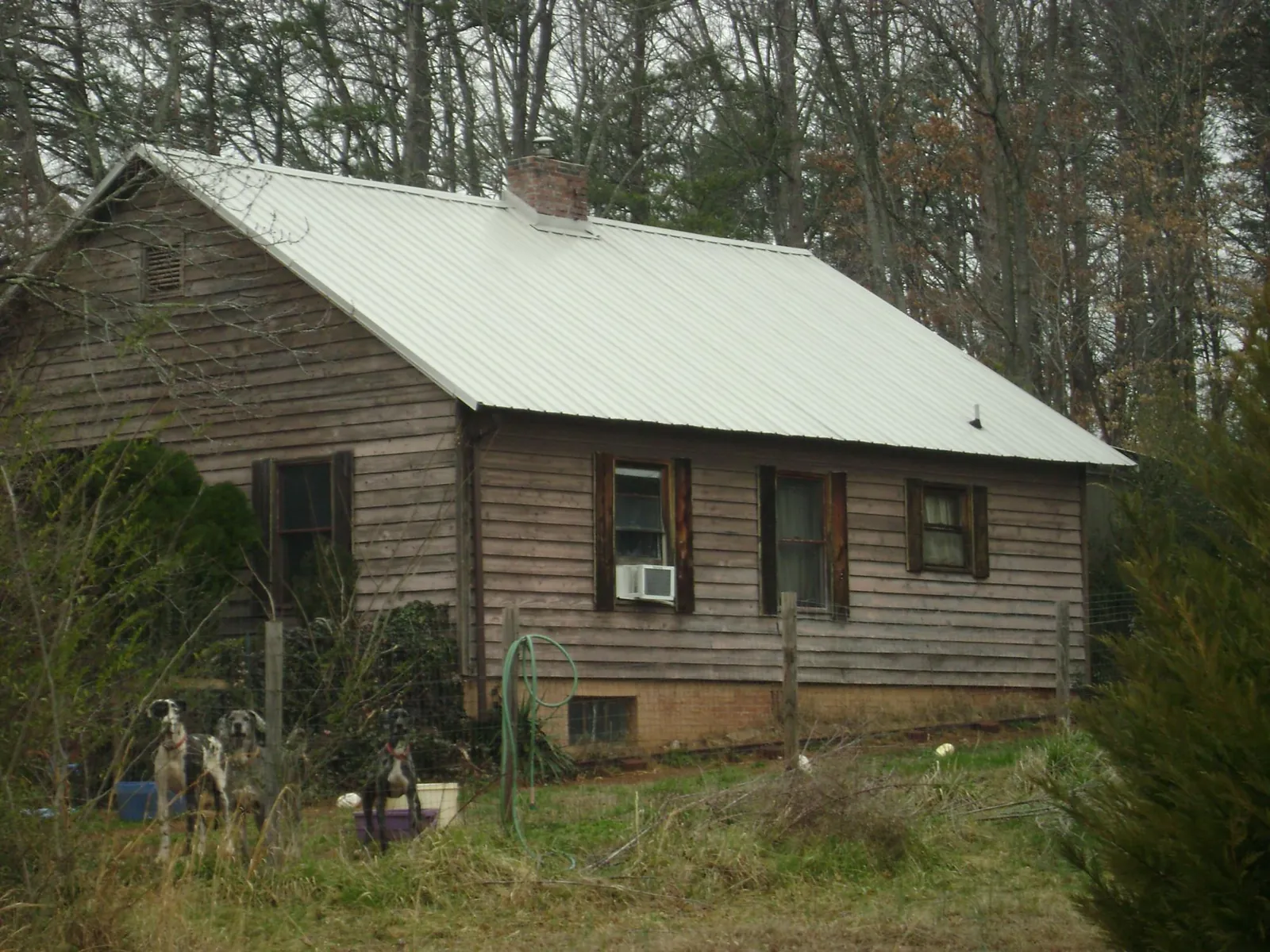 White metal roof on an old wood sided farmhouse, from a Metal Roof Installation job in Kenly